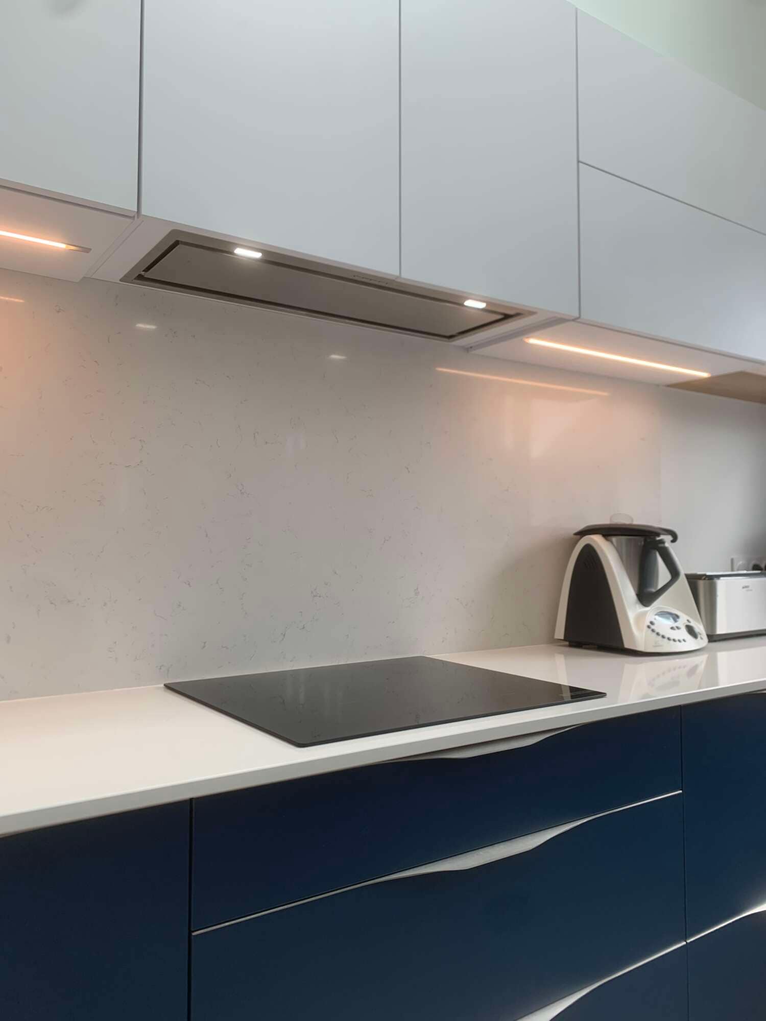 Hotte intégrée et éclairage sous meuble dans une cuisine sur mesure à Vitré