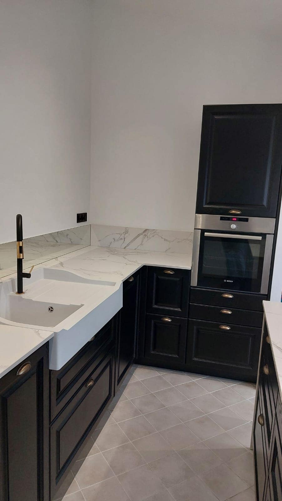 Cuisine sur mesure avec meubles noirs et plan de travail blanc à Vitré